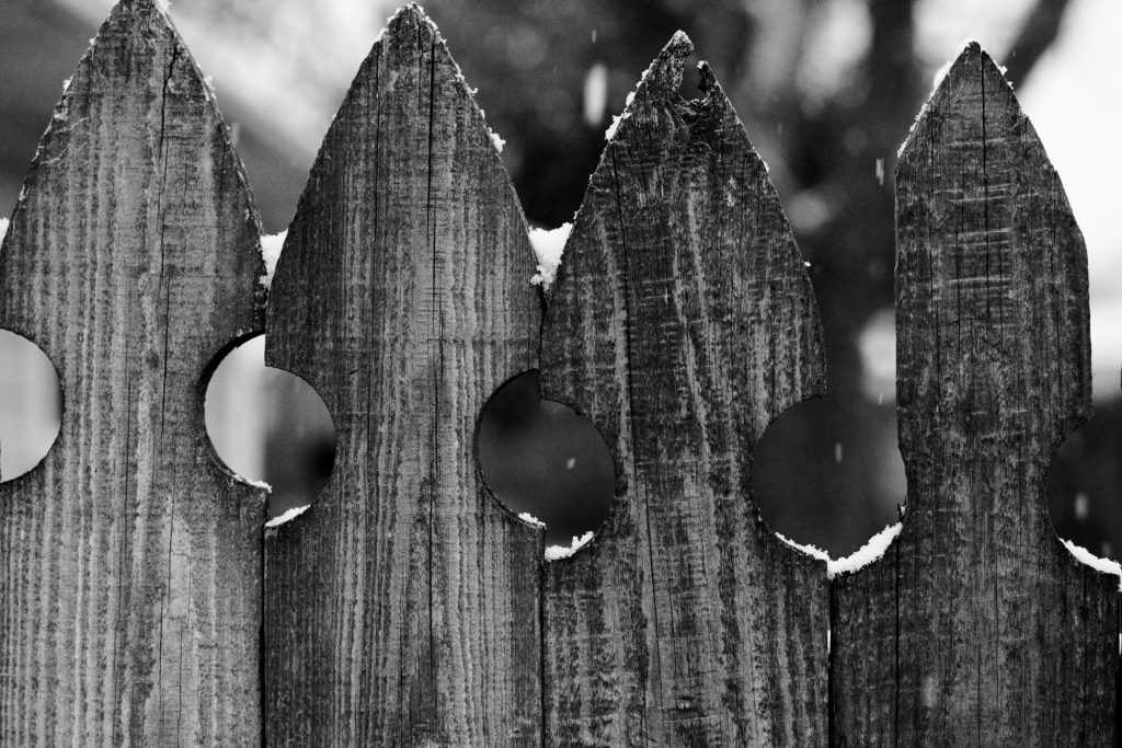 Light snow on wooden fence in black and white