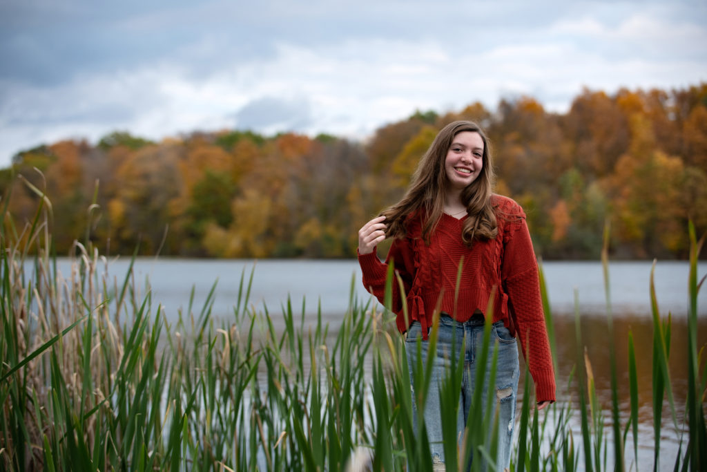 Senior portrait with lake and fall trees