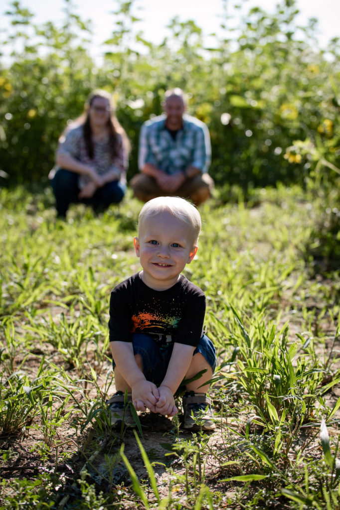 Toddler smiling with parents in background